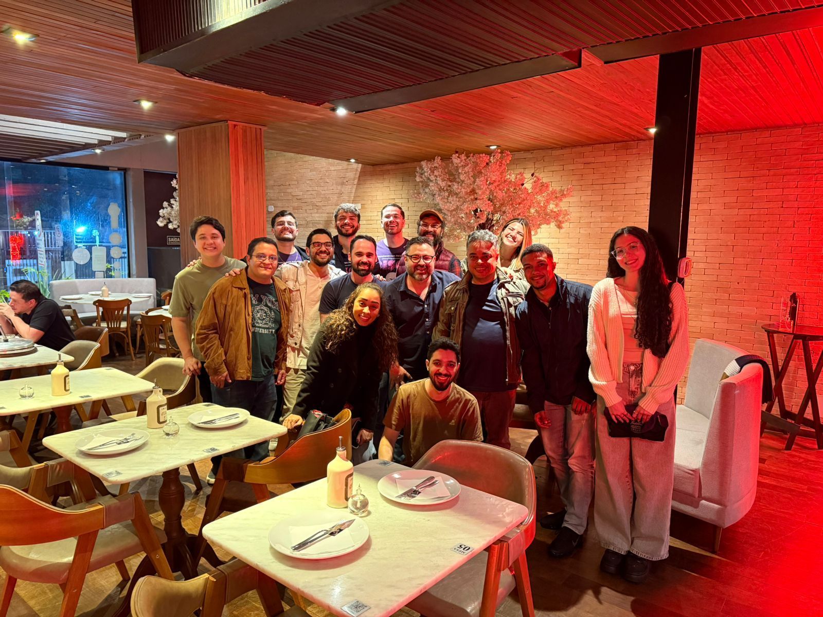 Time da Disco reunido num jantar, sob luz vermelha